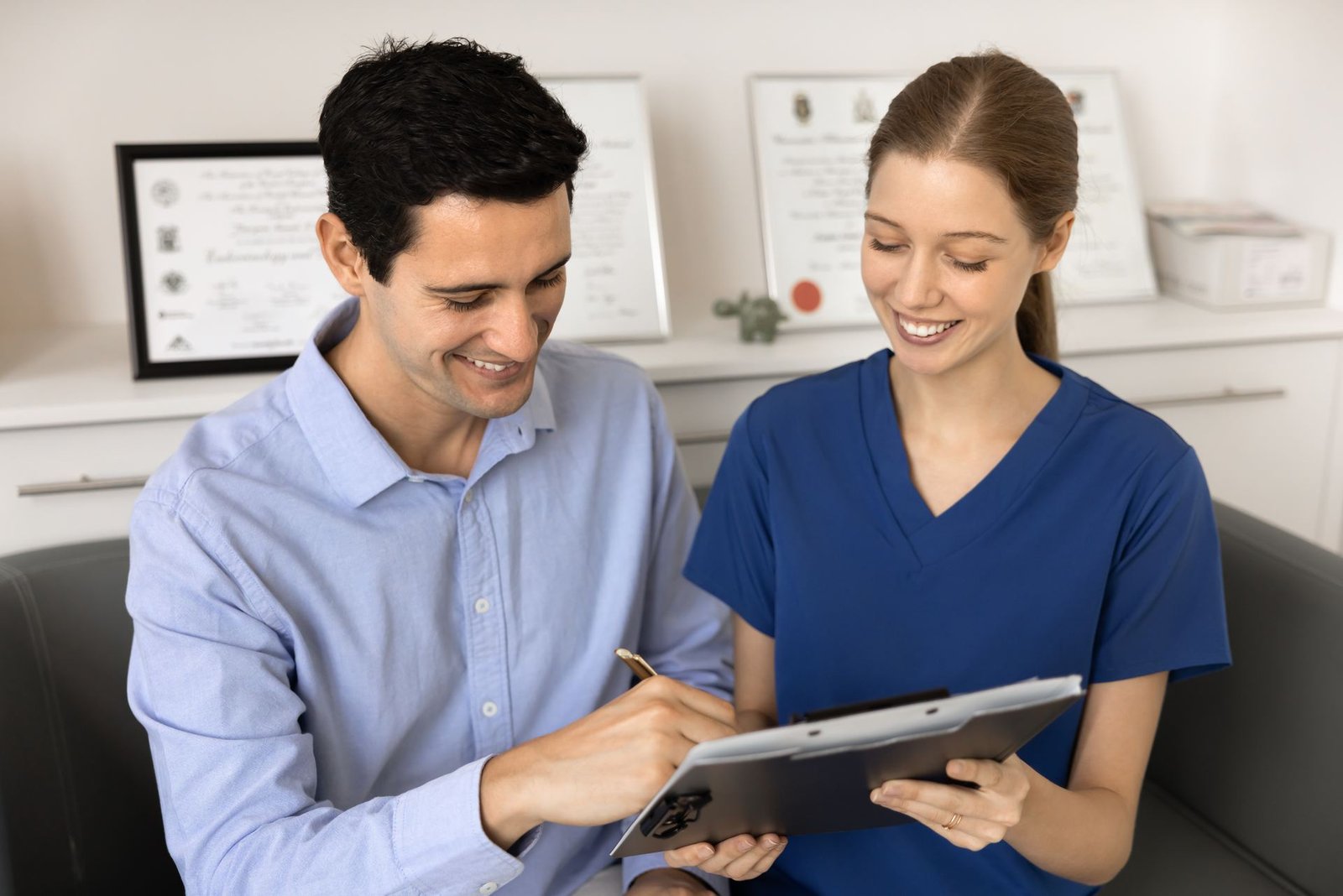 Front desk staff completing patient registration and insurance clearance