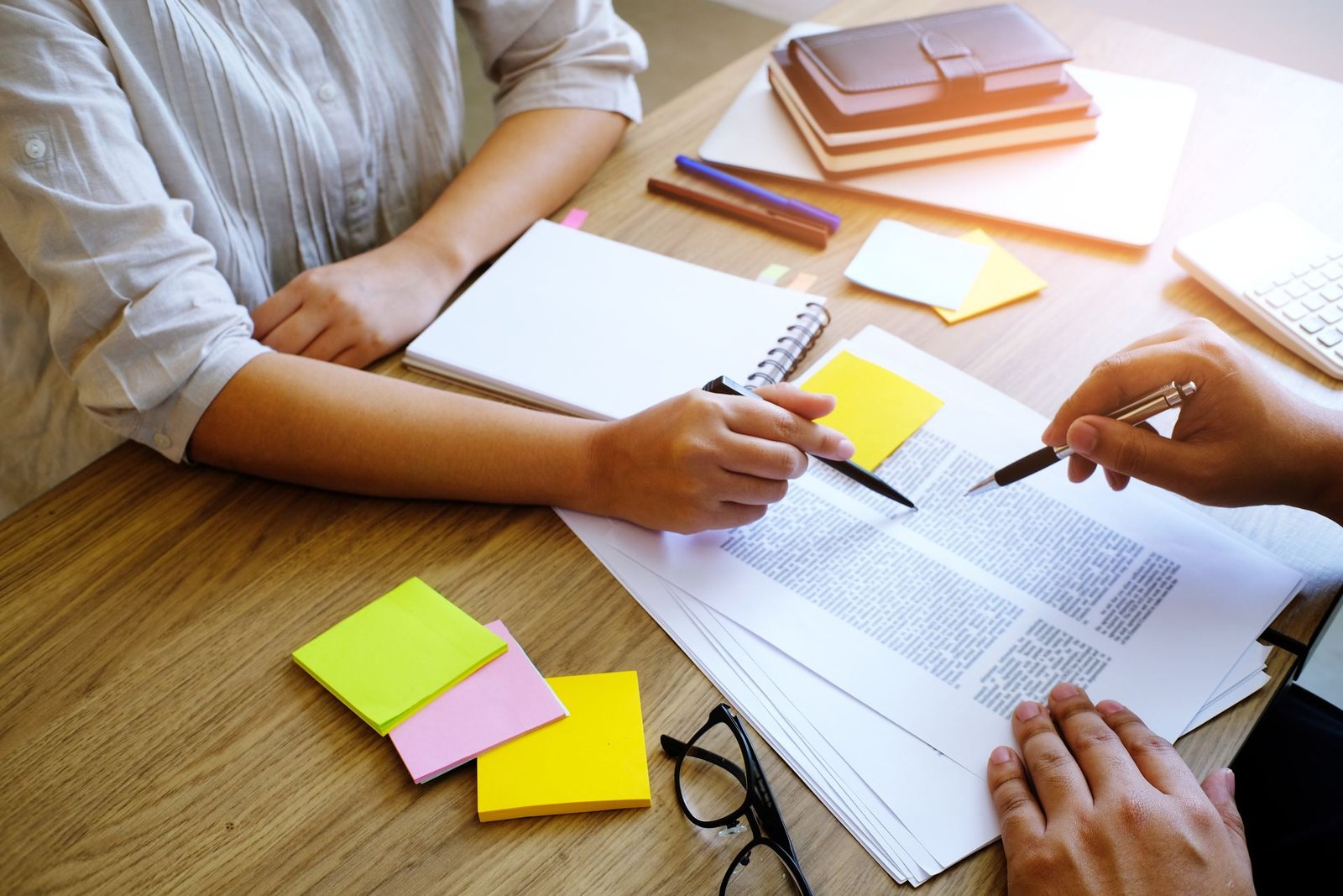 Two people annotating a printed revenue cycle report